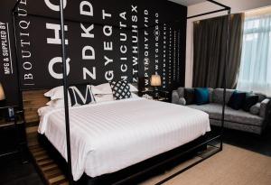 a bedroom with a large bed and a couch at M Boutique Kampar in Kampar