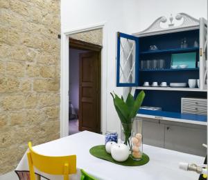 ナポリにあるCivico10のキッチン(青いキャビネット、テーブル、黄色い椅子付)
