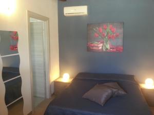 a bedroom with a bed with two lights on at Appartamento Vincenzina in Lampedusa
