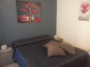 a bedroom with a bed with a painting on the wall at Appartamento Vincenzina in Lampedusa