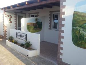 a house with two potted plants on the wall at Appartamento Vincenzina in Lampedusa