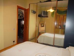 スカレアにあるCasa Angeloの鏡付きのベッドルーム1室、ベッド1台が備わるベッドルーム1室を提供しています。