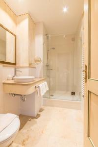uma casa de banho com um WC, um lavatório e um chuveiro em Hotel Post Murnau em Murnau am Staffelsee