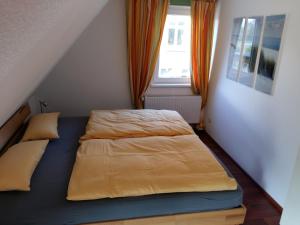 a small bedroom with a bed and a window at Ferienwohnung Am Schwanensee in Plön