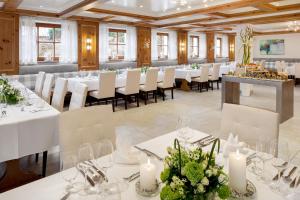 a banquet hall with white tables and chairs and candles at Hotel-Restaurant Distlerhof in Leinburg
