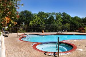 a large swimming pool with a red curb around it at Inn on Barons Creek in Fredericksburg