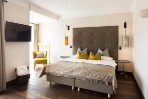 a bedroom with a large bed with yellow pillows at Hotel Burggräflerhof in Merano +146 photos