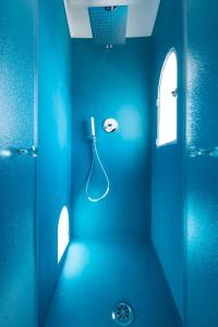 a blue bathroom with a shower with a hose at Dimore De Luca- Sea View in Amalfi