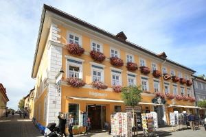 a yellow building with flower boxes on the side of it at Hotel Post Murnau in Murnau am Staffelsee