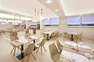 a restaurant with tables and chairs and a kitchen at Hotel Rivage in Sorrento