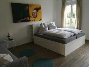 een slaapkamer met een bed in een kamer met een raam bij Unterm Blauregen in Wangen