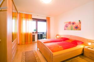 1 dormitorio con 1 cama grande con almohadas rojas en Appartements Peilerhof en Cermes