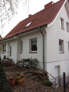 una casa bianca con tetto rosso di Ferienwohnung Am Schwanensee a Plön