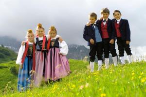 a group of children in dresses standing in a field at Pension Widderstein in Lech am Arlberg