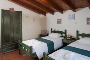 2 letti in una camera con pavimenti in legno di Kyriaki's Cozy Apartments ad Agia Marina Nea Kydonias