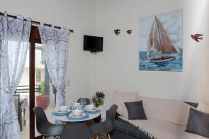 salon ze stołem i żaglówką na ścianie w obiekcie Kyriaki's Cozy Apartments w mieście Agia Marina Nea Kydonias