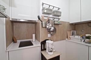 uma pequena cozinha com armários brancos e um balcão em my lovely Alfama's studios em Lisboa