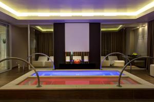 a hot tub in a room with a fireplace at Almar Jesolo Resort & Spa in Lido di Jesolo