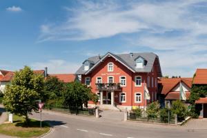 uma grande casa vermelha ao lado de uma rua em Gasthof zum Goldenen Lamm em Wettelsheim