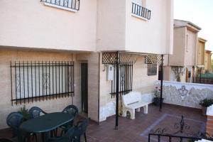 a patio with tables and chairs and a building at Casas los Rosales in Guadix