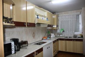 a kitchen with wooden cabinets and a stove top oven at Casas los Rosales in Guadix +8 photos