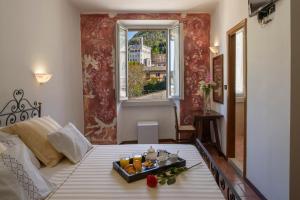 a bedroom with a bed with a tray of fruit on it at Hotel Porta Marmorea in Gubbio