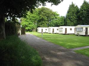 una fila de casas móviles blancas en un parque en Cosy Caravan at Blackmoor Farm, en Ludchurch