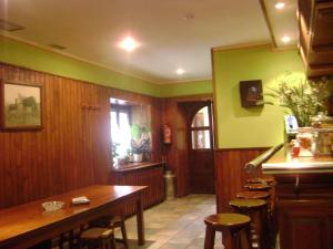 una sala da pranzo con tavolo e sedie in legno di Hostal Venta San Blas ad Almándoz