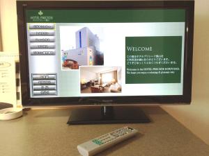 a computer monitor and a remote control sitting on a desk at Hotel Precede Koriyama in Koriyama
