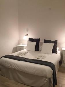 sypialnia z dużym łóżkiem z białą pościelą i poduszkami w obiekcie Chiaia House w mieście Napoli
