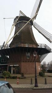 eine große Windmühle vor einem Gebäude in der Unterkunft Terrace Apartment Cyclades in Amsterdam