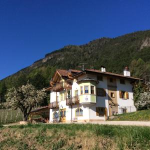 ein großes weißes Haus vor einem Berg in der Unterkunft Agriturismo Maso Tafol in Cloz