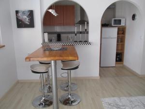 a kitchen with a counter and stools in a room at Casa Los Cerezos in Villamartin