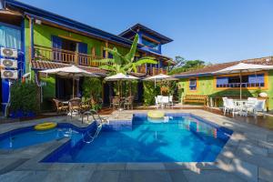 a swimming pool in front of a house at Pousada DiMari in Boicucanga