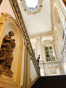 una escalera en un edificio con una estatua en la pared en TL Palazzo Fantuzzi, en Bolonia