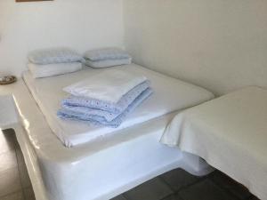 two beds in a room with towels on them at Rosys Little Village in Skala