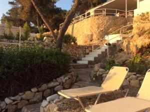 a pair of chairs and stairs in front of a house at Rosys Little Village in Skala