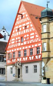 un bâtiment orange et blanc avec une tour d'horloge dans l'établissement Hotel Alte Vogtei, à Wolframs-Eschenbach