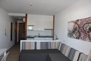 a living room with a couch and a kitchen at Venecia Apartments in Port d'Alcudia