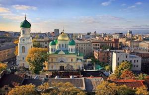 a large building with green and gold domes in a city at Апартаменти Іва в центрі на Набережній in Dnipro