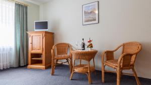 a room with a table and two chairs and a tv at Zum Fässle in Hagnau