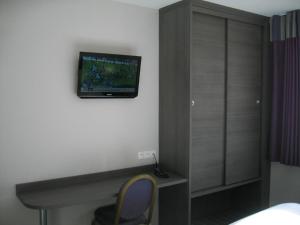 TV a/nebo společenská místnost v ubytování Hôtel des Rosiers