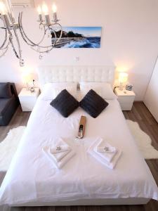 a bedroom with a white bed with a bow tie on it at The View in Zadar
