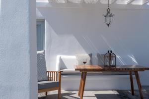a table and a chair in a room with white walls at Andromaches - by Senses Collection in Pirgos