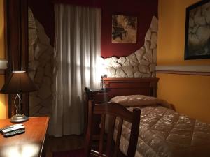 a bedroom with a bed and a desk with a lamp at Hotel Amadeus in Caserta