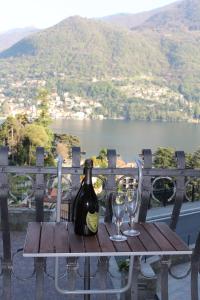 a table with a bottle of wine and two glasses at Larian Chalet in Moltrasio