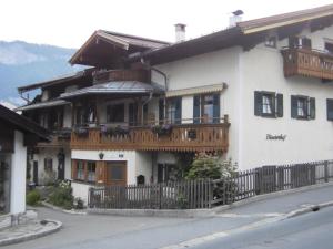 duży biały dom z drewnianym balkonem w obiekcie Binderhof w mieście Sankt Johann in Tirol