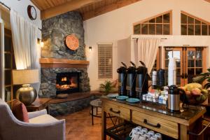 a living room with a stone fireplace and a table at El Pueblo Inn in Sonoma