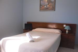 - une chambre avec un lit blanc et une photo sur le mur dans l'établissement Hotel Royal III, à Pesués