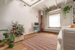 een woonkamer met een bank, een raam en een tapijt bij La Casina in Parma